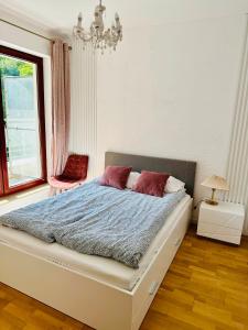 Un dormitorio con una gran cama blanca con almohadas rojas. en Pohulanka Old City - parking & balcony, en Gdansk