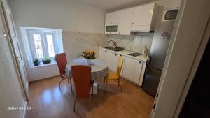 a kitchen with a table and chairs and a kitchen with a refrigerator at Downtown Dream Makarska in Makarska
