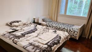 two beds in a room with a window at 3-bedroom lake view and near center apartment with sauna in Lahti