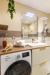 een keuken met een wasmachine en een wastafel bij Tournette, vue montagne & belle terrasse in Annecy