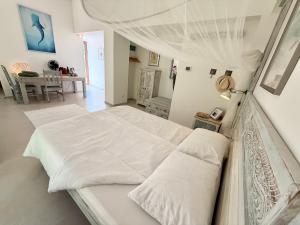 a bedroom with a white bed with a canopy at Cefalù Forest Hideout in Cefalù