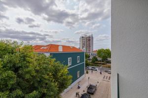 a blue building with an orange roof next to a street at Setúbal Luxury Apartment in Setúbal