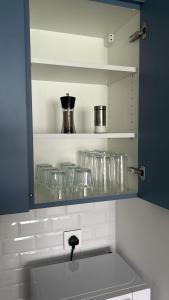 a kitchen with a shelf with glasses on it at Ayla Aqaba Azure 2 bedroom 0922 in Aqaba