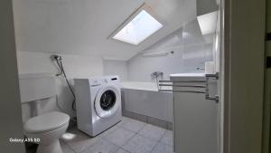 a bathroom with a toilet and a washing machine at Downtown Dream Makarska in Makarska