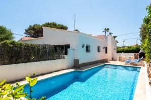 a villa with a swimming pool in front of a house at New! Villa Margarita - Menorca in Punta Prima