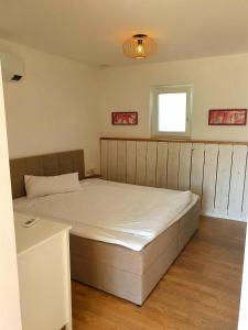 a bedroom with a bed and a window at Sinnvoll - Ferienwohnung1 in Sankt Anna am Aigen