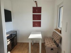 a living room with a white table and a couch at Sinnvoll - Ferienwohnung1 in Sankt Anna am Aigen