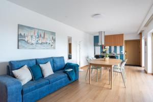 un soggiorno con un divano blu e un tavolo di Villa Aqua Madalena by MP a Madalena