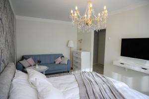 a living room with a bed and a chandelier at Side Apartments in Rakvere