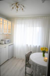 a kitchen with a table and a white curtain at Side Apartments in Rakvere