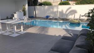 a swimming pool with chairs and a table next to it at Just Light in San Leone