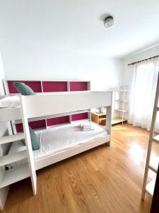 a white bunk bed in a room with a wooden floor at Villa Aire in Cala en Blanes