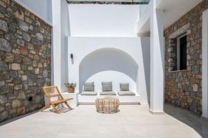 two beds in a room with a brick wall at Elements Villas in Lartos