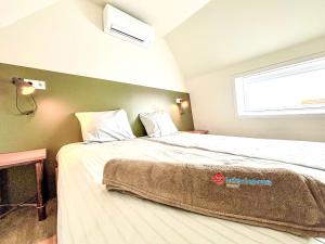 Un dormitorio con una cama grande con ventana. en Holiday Home Beach House Westkapelle 103 C by Interhome, en Westkapelle