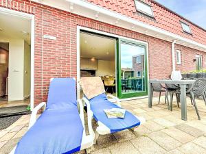 un par de sillas y una mesa en un patio en Holiday Home Beach House Westkapelle 103 C by Interhome, en Westkapelle
