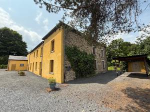 a yellow brick building with a large yard at Arduinna's Nest B&B in Neufchâteau