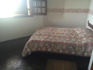 een slaapkamer met een bed met een quilt bij Casa Ubatuba vista para o mar in Ubatuba