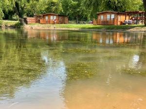 EvertonLakeside Lodge 2, With Log burning Hot tub的水体,有房子的背景