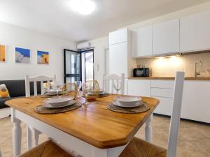 a kitchen and dining room with a wooden table at Apartment Sa Minda by Interhome in Valledoria