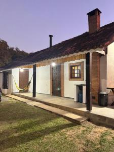a house with a hammock in front of it at Recanto Manacá- Monte Verde in Camanducaia