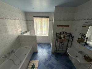 a bathroom with a tub and a toilet and a sink at Arduinna's Nest B&B in Neufchâteau