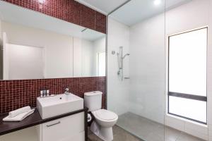 a bathroom with a toilet and a sink and a shower at Oaks Cable Beach Resort in Broome