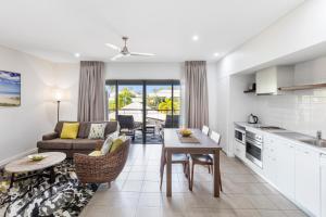 eine Küche und ein Wohnzimmer mit einem Sofa und einem Tisch in der Unterkunft Oaks Cable Beach Resort in Broome