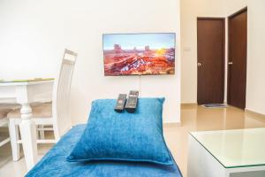 two remote controls sitting on a blue pillow in a room at The Loft at Elixia in Sri Jayewardenepura Kotte +48 photos