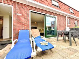 un par de sillas y una mesa en un patio en Holiday Home Beach House Westkapelle 103 D by Interhome, en Westkapelle