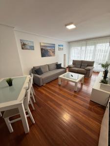 a living room with a couch and a table at El Rincón del Faro - Parking incluido in San Vicente de la Barquera