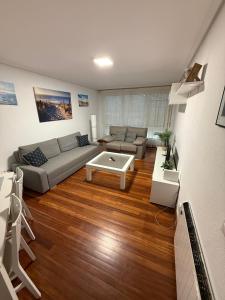 a living room with a couch and a table at El Rincón del Faro - Parking incluido in San Vicente de la Barquera
