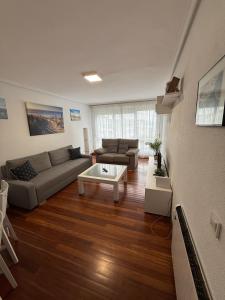 a living room with a couch and a coffee table at El Rincón del Faro - Parking incluido in San Vicente de la Barquera