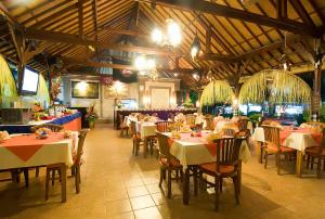a dining room with tables and chairs in a restaurant at Kusnadi Hotel in Legian