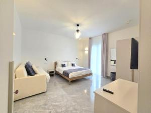 a bedroom with a bed and a couch and a television at Just Light in San Leone