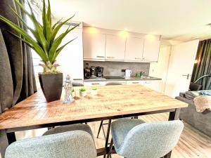 una cocina con una mesa de madera con sillas y una planta en Holiday Home Beach House Westkapelle 2B by Interhome, en Westkapelle