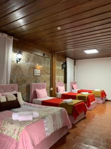 a room with four beds with pink and green sheets at Casa Augusta - QUINTA in Penafiel +183 photos
