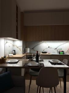 a kitchen with a table with plates and wine glasses at Azul Apartment Orikum in Orikum