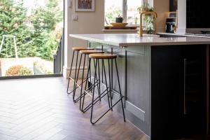 a kitchen with a counter with stools at a bar at City SuperHost Hale Family Home in Hale