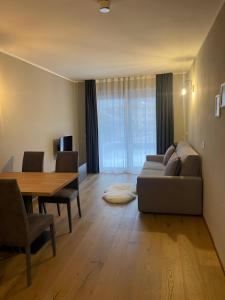 a living room with a couch and a dining room table at HOTIDAY Bormio Apartments in Bormio
