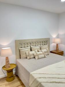 a bedroom with a large bed with two lamps at Happy Stork Tróia Beach Flat in Troia +75 photos