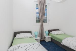 two twin beds in a room with a window at Sky Split Apartment in Split