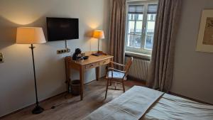 a hotel room with a desk with a bed and a television at 1830 Zur Alten Posthalterei in Euskirchen