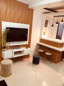 a living room with a large television and two stools at Z House of Guests 3 Airport Dvo in Davao City