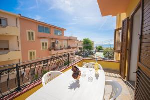 een witte tafel en stoelen op een balkon bij La Caletta 1 in La Caletta