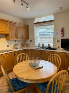 a kitchen with a round wooden table and chairs at The Towerview Coach Houses in Perth