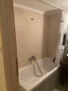 a bathroom with a bath tub with a shower curtain at Sofia's Apartment in Nea Moudania +4 photos
