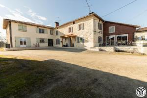 a large house with a dirt road in front of it at Le gîte du besson in Cassagne