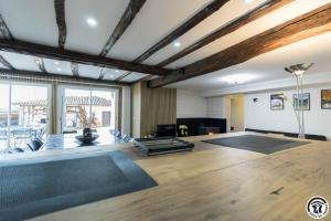 a living room with a large room with wood ceilings at Le gîte du besson in Cassagne