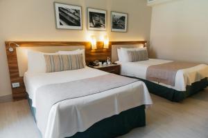 a hotel room with two beds in a room at Emporio Cancun - Buy All Inclusive Option in Cancún