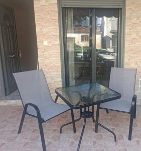 two chairs and a table on a patio at Sofia's Apartment in Nea Moudania